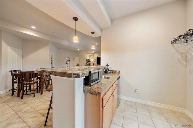 kitchen with tile counters, a kitchen bar, light tile patterned floors, baseboards, and recessed lighting