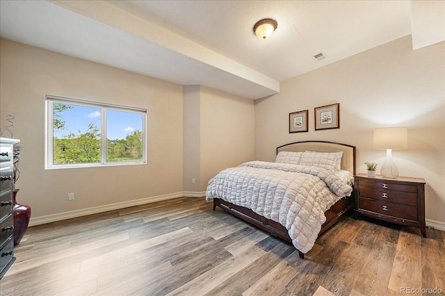 bedroom featuring wood finished floors and baseboards