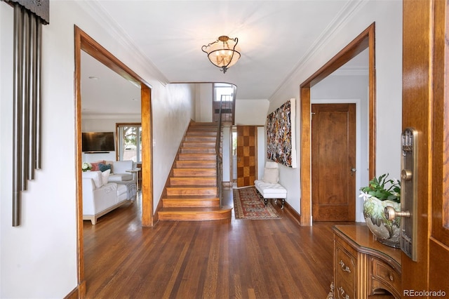 entrance foyer featuring crown molding, dark wood-type flooring, baseboards, and stairs