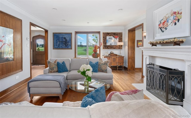 living room with crown molding, light wood-type flooring, a fireplace, and baseboards