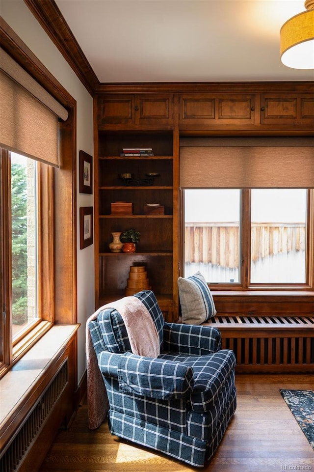 living area featuring crown molding, a wealth of natural light, and wood finished floors
