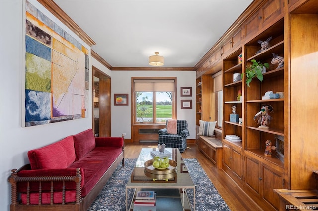 living area featuring baseboards, ornamental molding, and wood finished floors