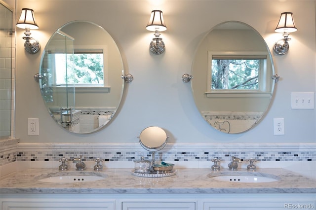bathroom featuring plenty of natural light, double vanity, and a sink