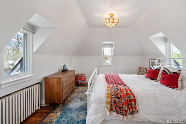 bedroom featuring lofted ceiling, dark wood finished floors, multiple windows, and radiator heating unit