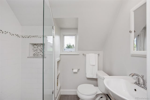 bathroom with a sink, vaulted ceiling, a wealth of natural light, and a tile shower