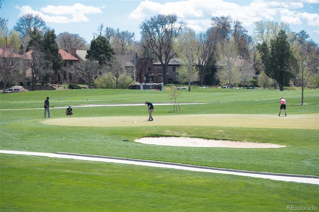 view of home's community with a yard and view of golf course