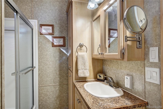 bathroom with vanity and a shower with shower door