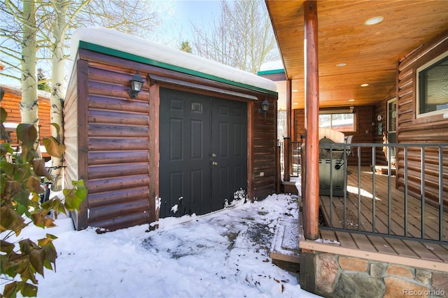 snow covered property entrance featuring a porch