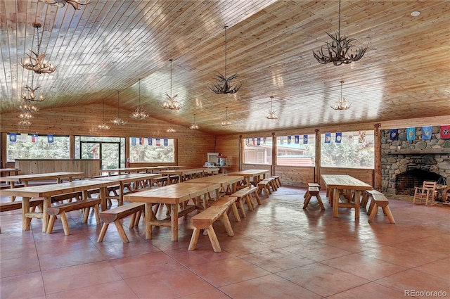 tiled dining space featuring a stone fireplace, wooden ceiling, and high vaulted ceiling