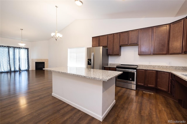 kitchen featuring light stone countertops, appliances with stainless steel finishes, dark wood-type flooring, pendant lighting, and lofted ceiling