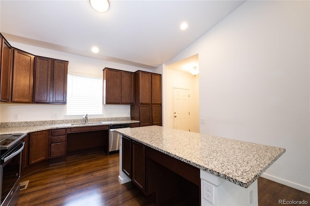 kitchen with vaulted ceiling, dark hardwood / wood-style floors, light stone countertops, appliances with stainless steel finishes, and a kitchen island