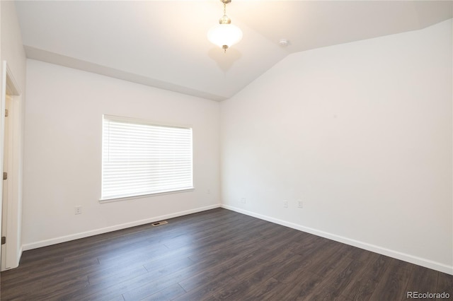 spare room with vaulted ceiling and dark hardwood / wood-style floors