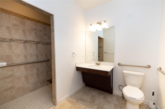 bathroom featuring tile patterned floors, vanity, toilet, and tiled shower