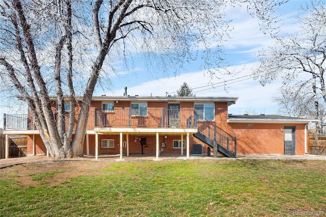 rear view of house featuring a yard, brick siding, stairs, and a patio area