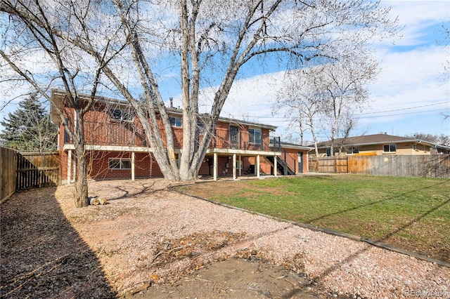 rear view of property with stairway, a yard, a fenced backyard, and brick siding