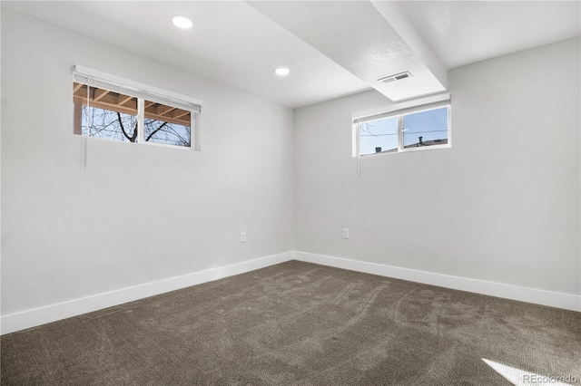 below grade area featuring recessed lighting, baseboards, visible vents, and dark colored carpet