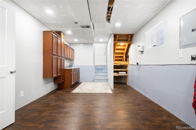 interior space with electric panel, visible vents, and dark wood-style floors