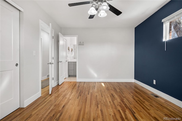 unfurnished bedroom with visible vents, ceiling fan, baseboards, and wood finished floors