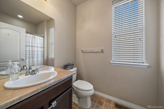 full bath featuring visible vents, toilet, vanity, a shower with curtain, and baseboards