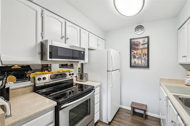 kitchen featuring baseboards, dark wood-type flooring, light countertops, white cabinets, and stainless steel appliances