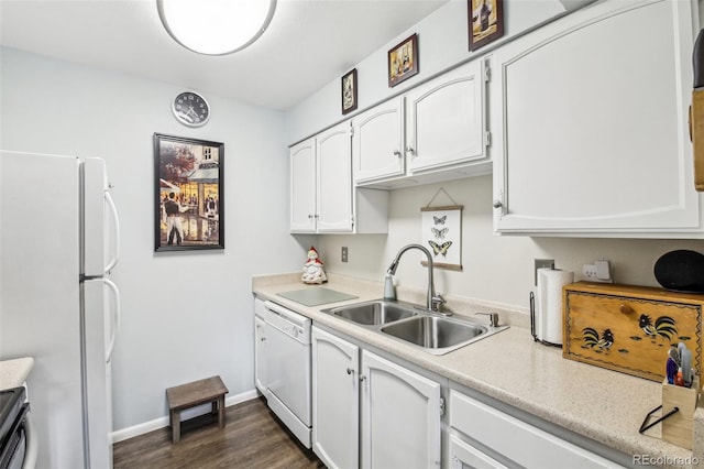 kitchen with white cabinets, a sink, white appliances, light countertops, and dark wood-type flooring