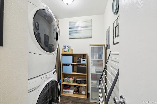 laundry area featuring laundry area, stacked washer / drying machine, and wood finished floors