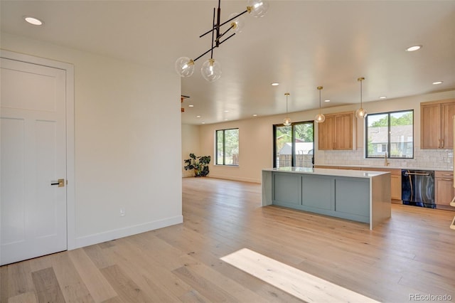 717 Marquette Ave, Buena Vista, CO 81211 - kitchen featuring dishwashing machine, a center island, light wood-style floors, light countertops, and tasteful backsplash