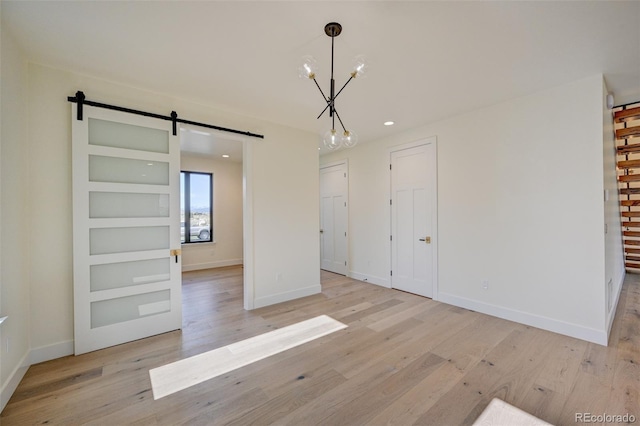 717 Marquette Ave, Buena Vista, CO 81211 - unfurnished dining area featuring a barn door, light wood-type flooring, recessed lighting, and a chandelier