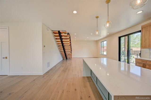 717 Marquette Ave, Buena Vista, CO 81211 - kitchen featuring light wood-type flooring, recessed lighting, open floor plan, pendant lighting, and light stone countertops