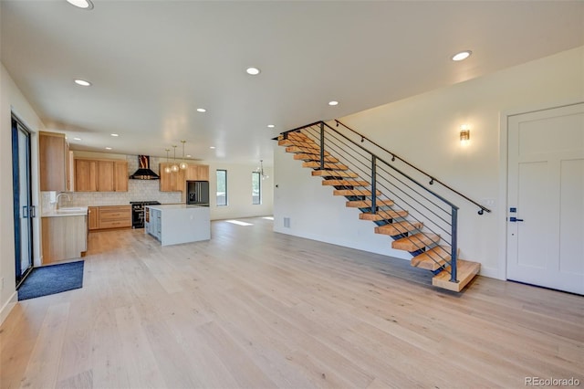717 Marquette Ave, Buena Vista, CO 81211 - kitchen with wall chimney exhaust hood, fridge with ice dispenser, stainless steel stove, light countertops, and open floor plan