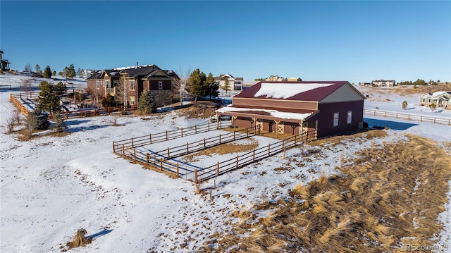 snow covered back of property featuring an outdoor structure