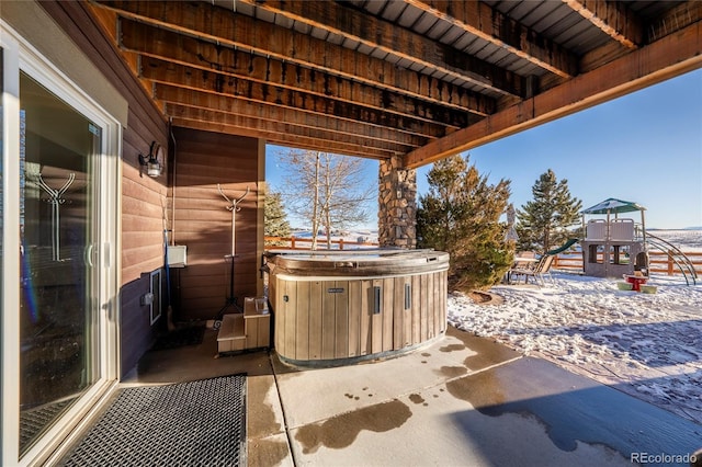 view of patio featuring a playground and a hot tub