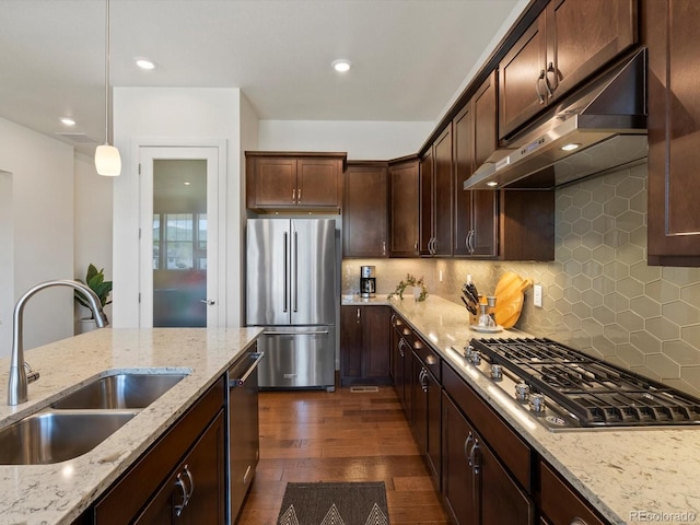 10258 W Coal Mine Pl, Littleton, CO 80127 - kitchen with stainless steel appliances, a sink, under cabinet range hood, dark wood-type flooring, and decorative backsplash