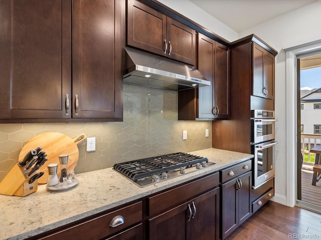 10258 W Coal Mine Pl, Littleton, CO 80127 - kitchen featuring under cabinet range hood, appliances with stainless steel finishes, dark wood-type flooring, and healthy amount of natural light