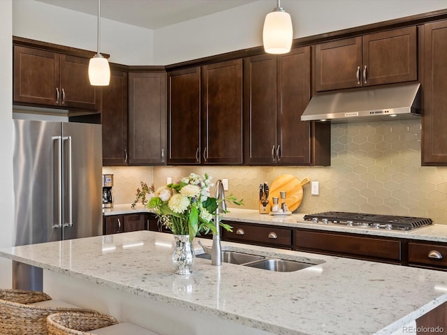 10258 W Coal Mine Pl, Littleton, CO 80127 - kitchen featuring under cabinet range hood, stainless steel appliances, dark brown cabinets, and light stone countertops