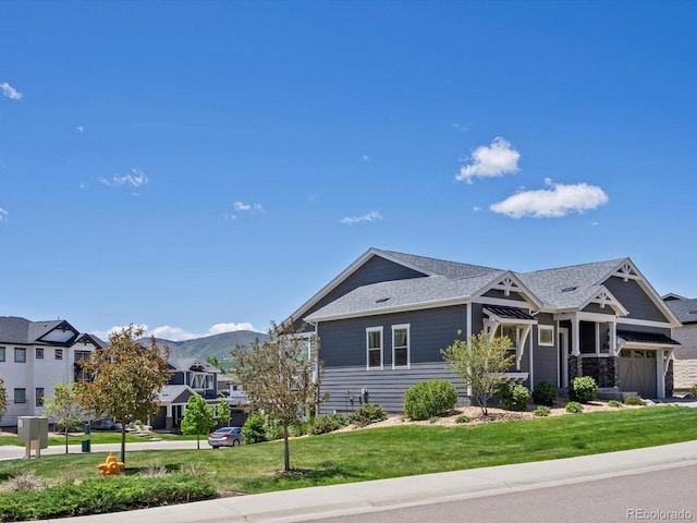 10258 W Coal Mine Pl, Littleton, CO 80127 - view of front of house with a front lawn, an attached garage, a mountain view, a shingled roof, and a residential view