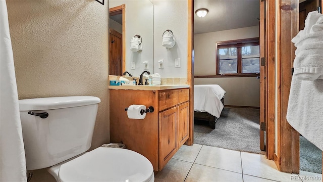 bathroom featuring vanity, tile patterned floors, and toilet