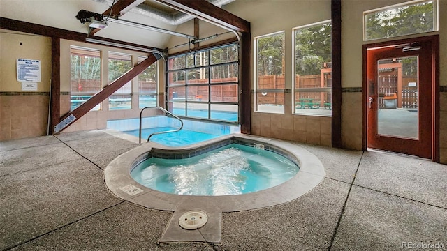view of swimming pool with a patio and an indoor hot tub