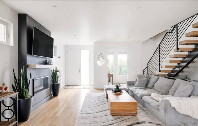 2685 S Acoma St, Denver, CO 80223 - living room featuring stairs, light wood-style floors, and a glass covered fireplace