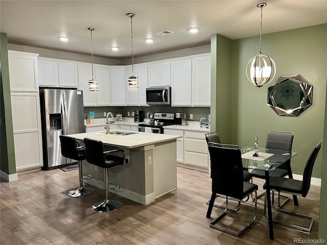 15354 W 64th Ln Unit 108, Arvada, CO 80007 - kitchen with appliances with stainless steel finishes, wood finished floors, light countertops, white cabinets, and recessed lighting