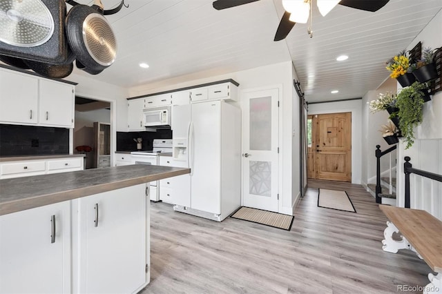 6455 Field St, Arvada, CO 80004 - kitchen featuring white appliances, dark countertops, recessed lighting, white cabinets, and light wood-type flooring