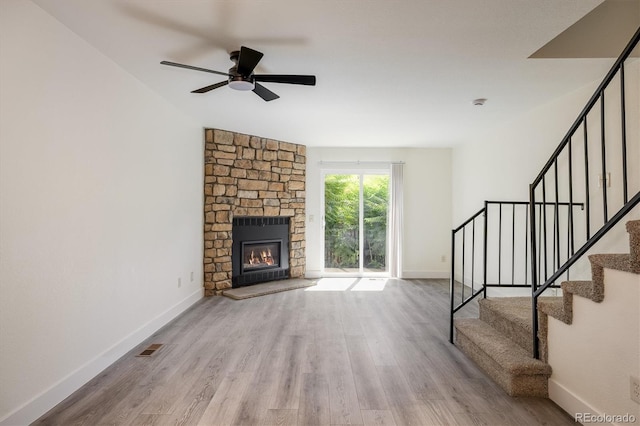 2933 W 81st Ave Unit F, Westminster, CO 80031 - unfurnished living room featuring ceiling fan, wood finished floors, stairs, and a stone fireplace