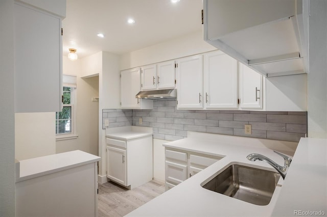 2933 W 81st Ave Unit F, Westminster, CO 80031 - kitchen featuring under cabinet range hood, tasteful backsplash, light wood-type flooring, white cabinetry, and recessed lighting