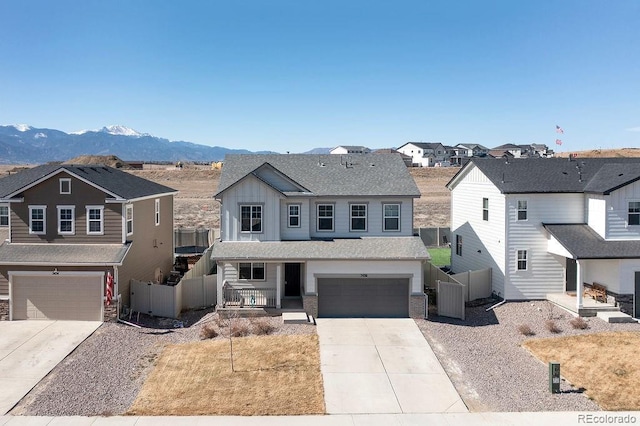 view of front facade featuring fence, a residential view, a porch, driveway, and a mountain view