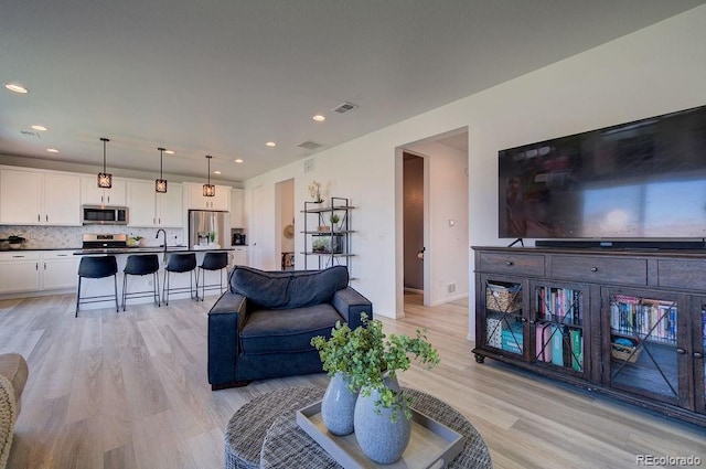 living area featuring visible vents, recessed lighting, and light wood-type flooring