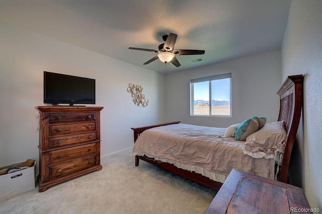 carpeted bedroom with visible vents, a textured ceiling, and ceiling fan