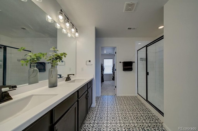 full bathroom featuring visible vents, a shower stall, and a sink