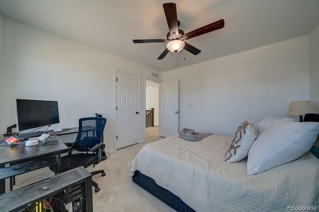 bedroom with visible vents, light colored carpet, and a ceiling fan