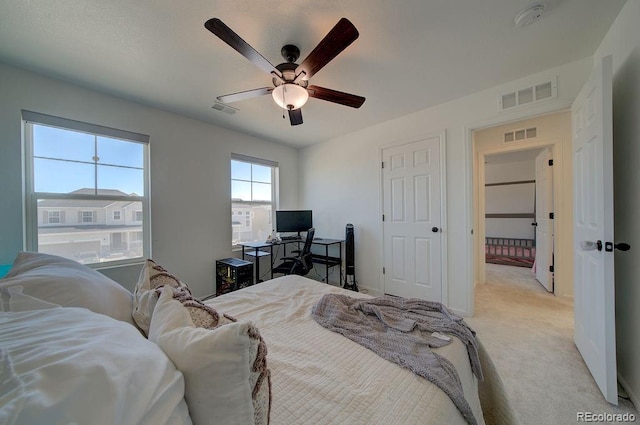 bedroom featuring light colored carpet, visible vents, and ceiling fan