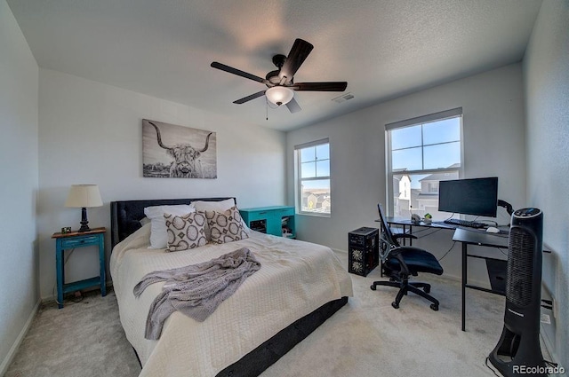 bedroom with visible vents, baseboards, carpet, a textured ceiling, and a ceiling fan